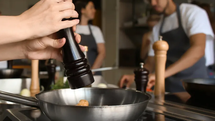 young woman preparing meal in restaurant kitchen during cooking classes